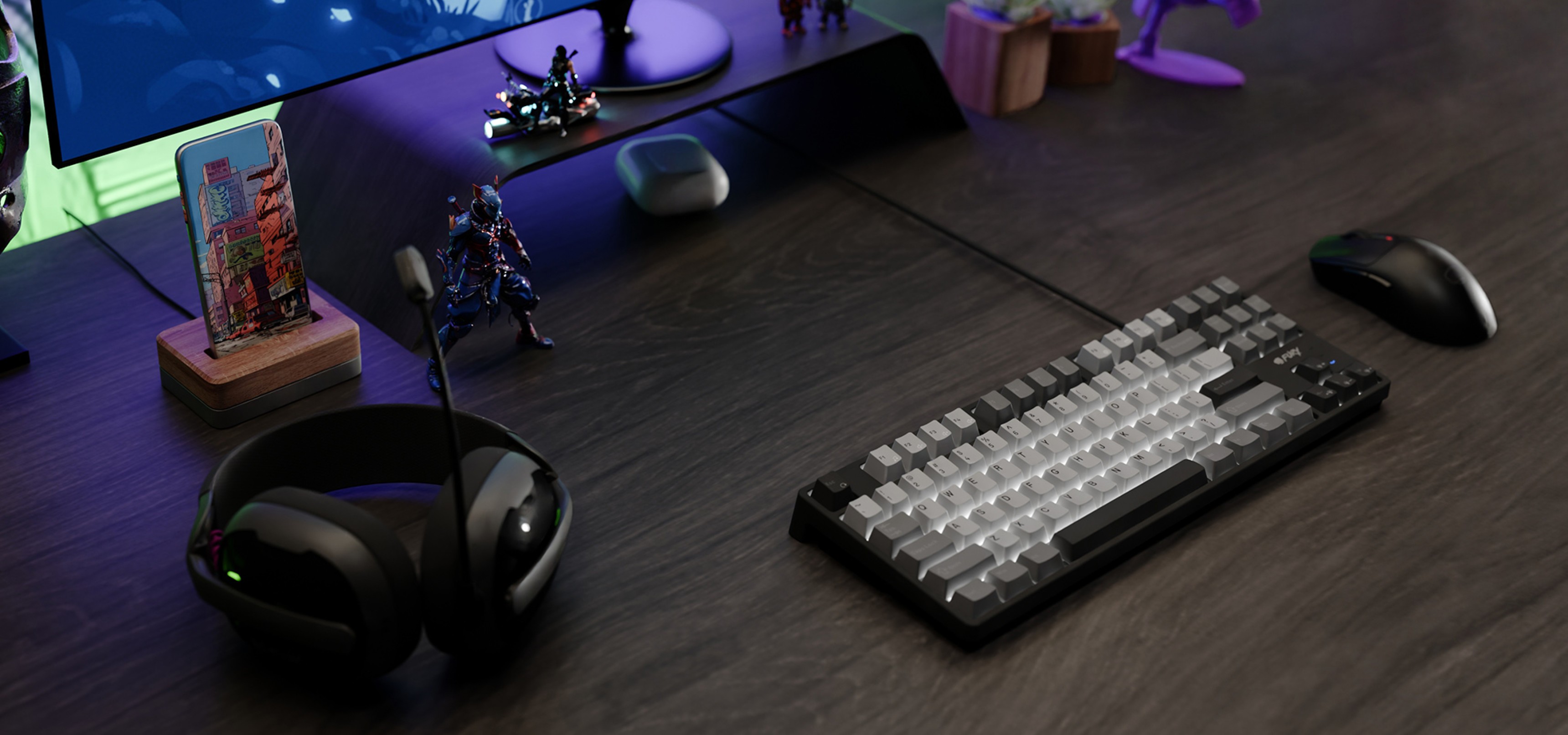 A keyboard, mouse, and headset are arranged on a dark wooden desk with figurines nearby.