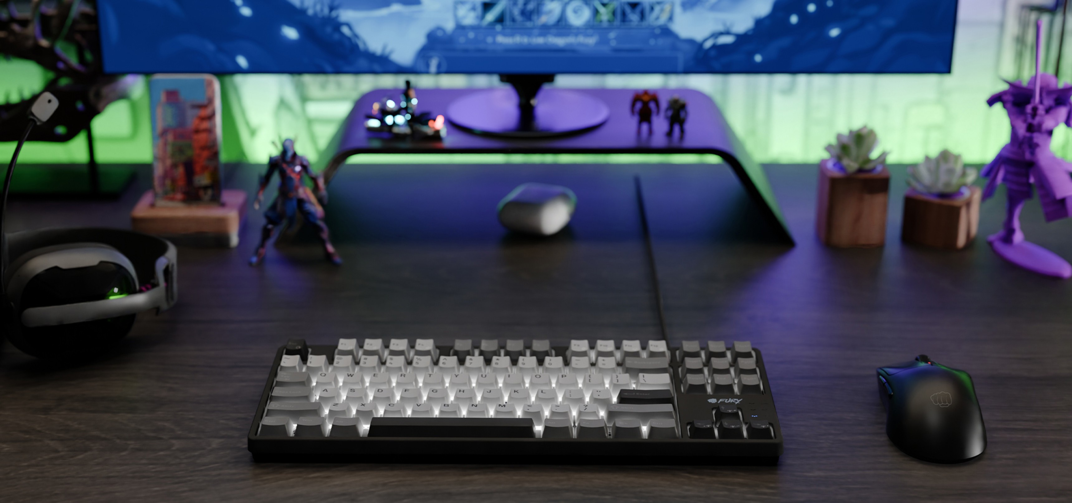 Keyboard with clear and dark keys on a desk near a mouse and gaming figures.